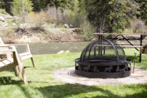 stone fire pit with a picnic table by the river