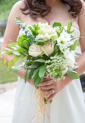 mountain bride in wedding dress holding a white and green bouquet