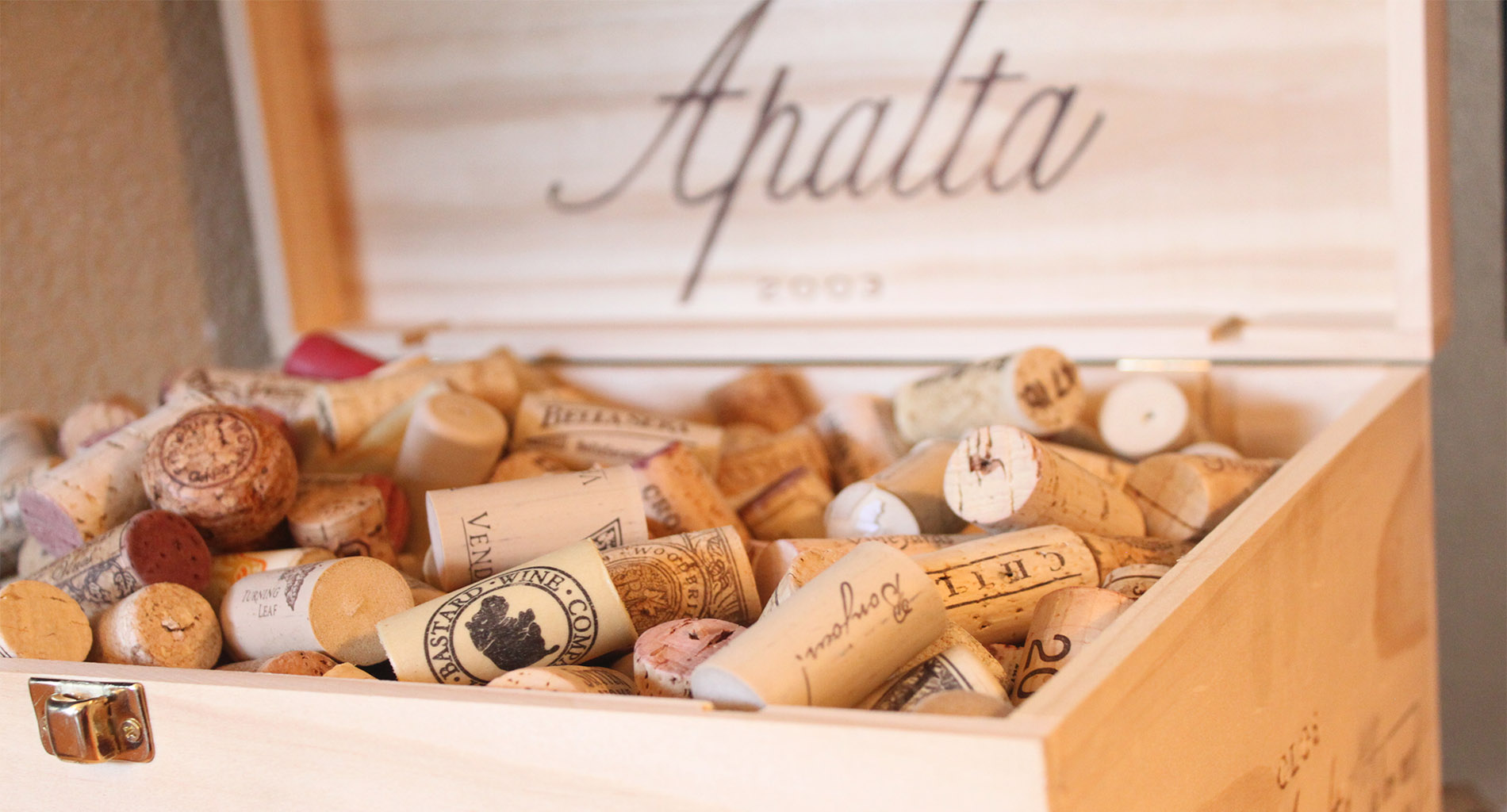 Close-up of colorful wine corks in a wooden box with hinged lid