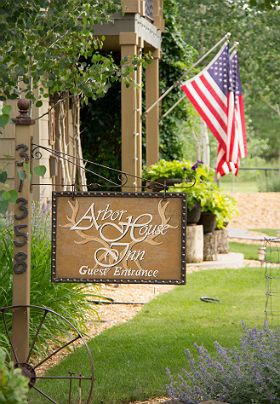 front view of the b&b entrance with sign and American flags