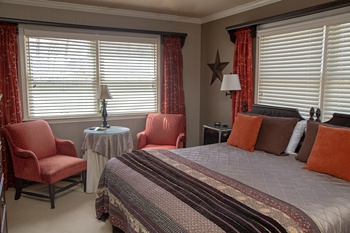 Guest room #1 with bedding with autumn colors and seating for two