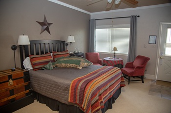 guest room with fishing theme with luxury bedding with autumn colors and seating for two by the window